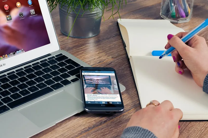 ノートパソコンとスマートフォンで作業する様子